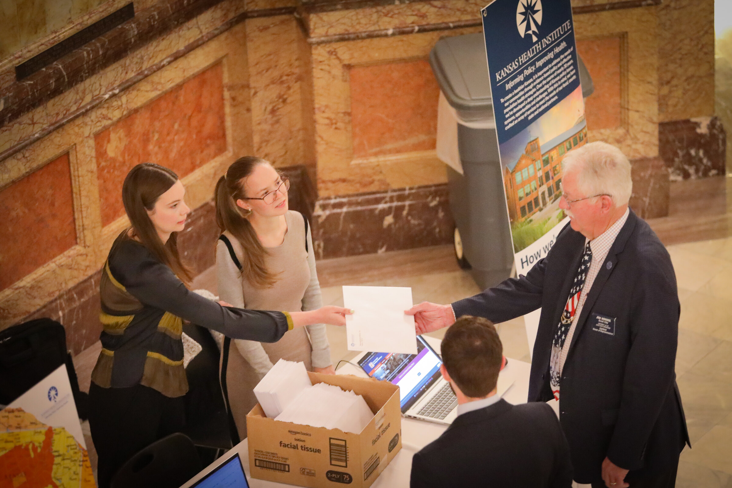 A County Health Rankings handout is shared at the Kansas Statehouse