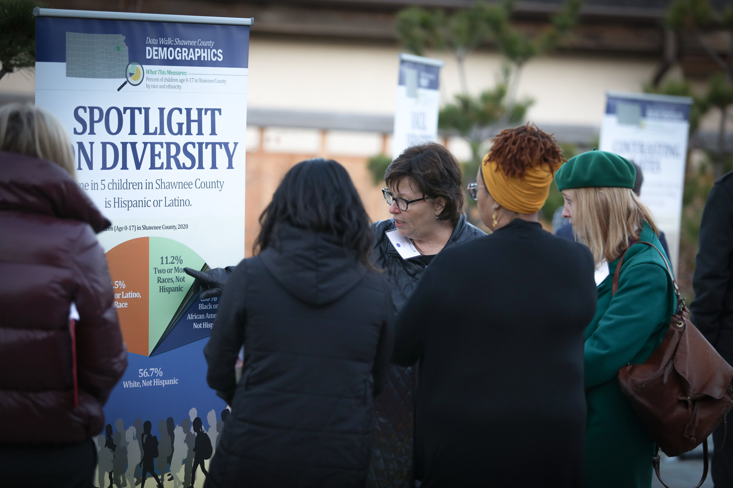Participants discuss a Shawnee County Data Walk installation outdoors