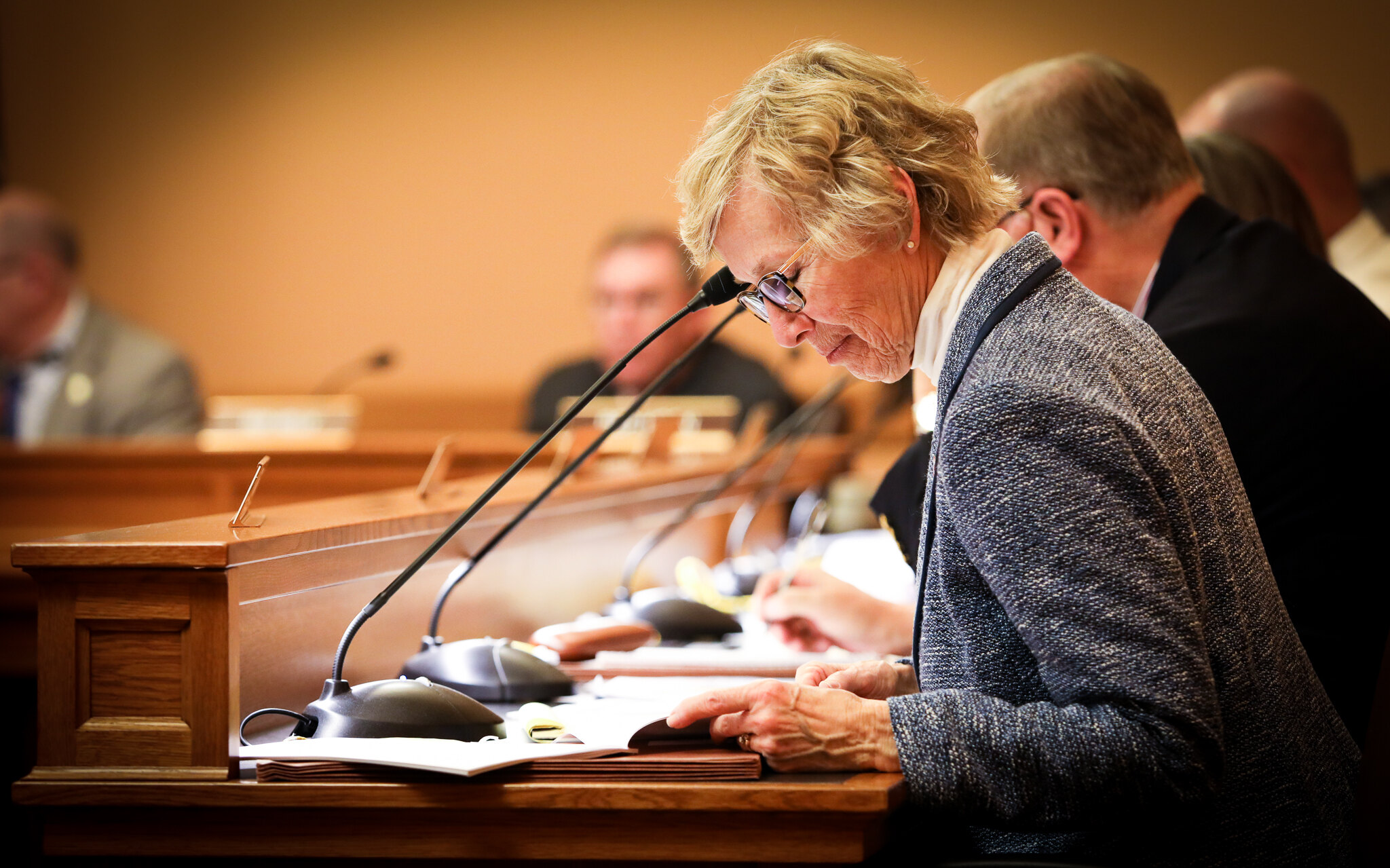 A legislator studies materials during a committee hearing